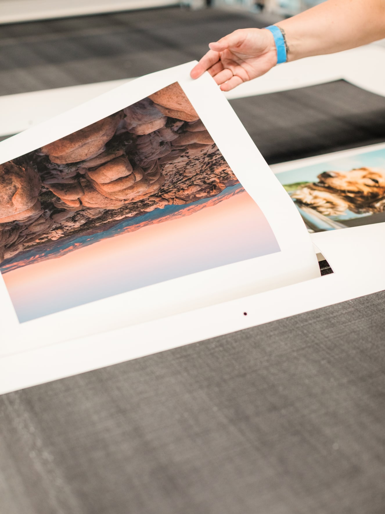 Hands lifting up a freshly cut fine art print